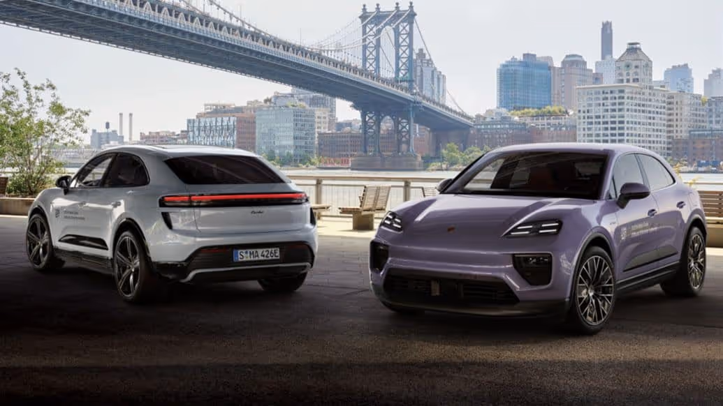 Two Porsche Macan in front of a bridge.