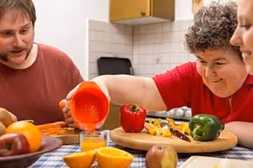 Three persons cooking together.